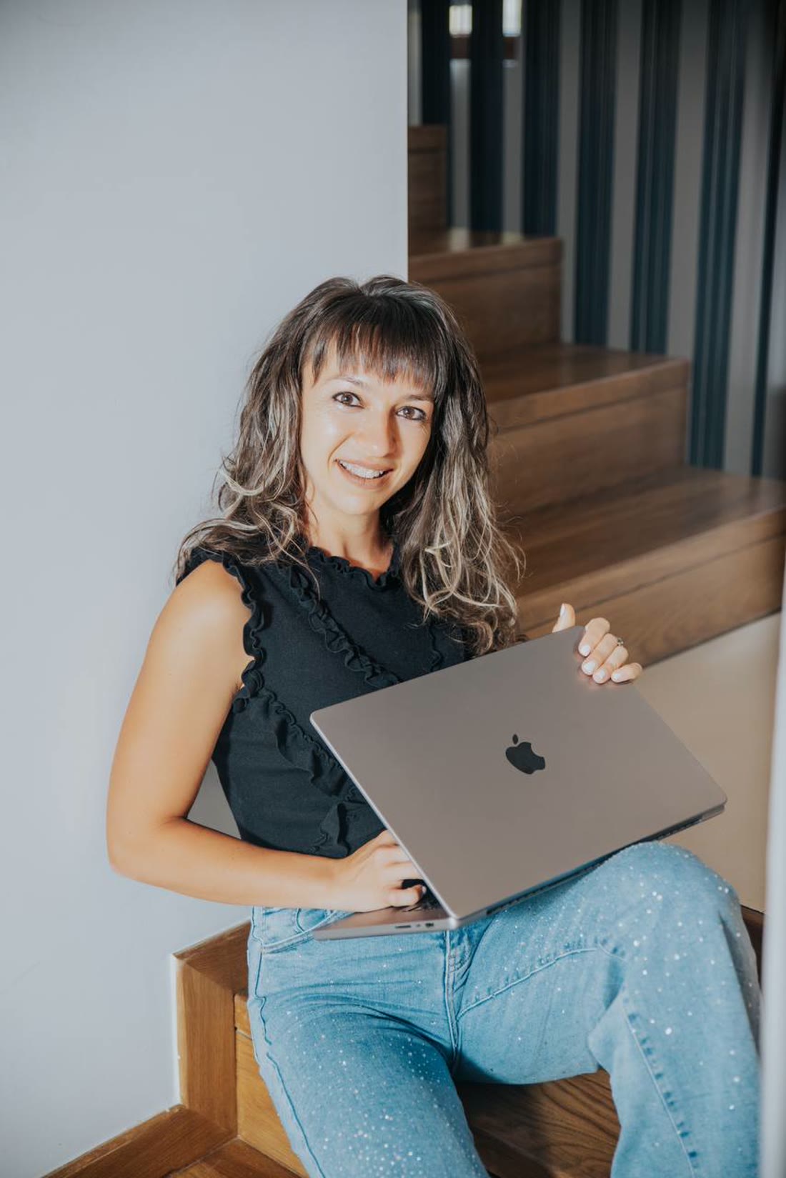 Marchela working on a laptop on outdoor steps